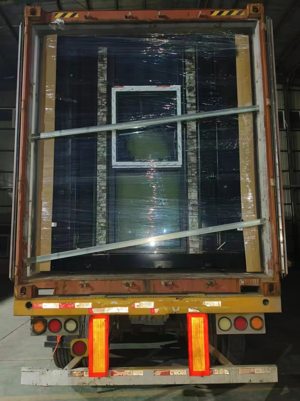 Rückansicht eines Transportcontainerhauses mit verstärkten Stahltüren und sicheren Verriegelungsstäben, hergestellt von einer chinesischen Fabrik für Containerhäuser für den Export von Massengütern, den Transport nach Übersee und modulare Wohnprojekte.