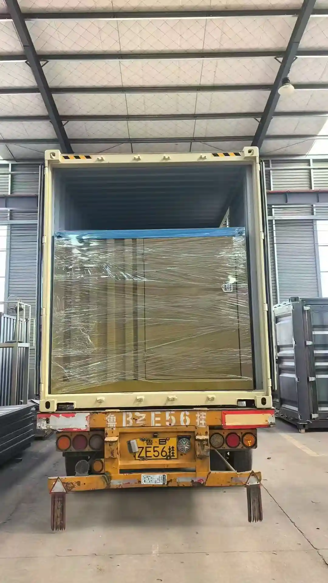 A custom yellow container swimming pool being precision-loaded into a shipping container using a heavy-duty forklift and crane, wrapped in protective industrial stretch film for international transit.