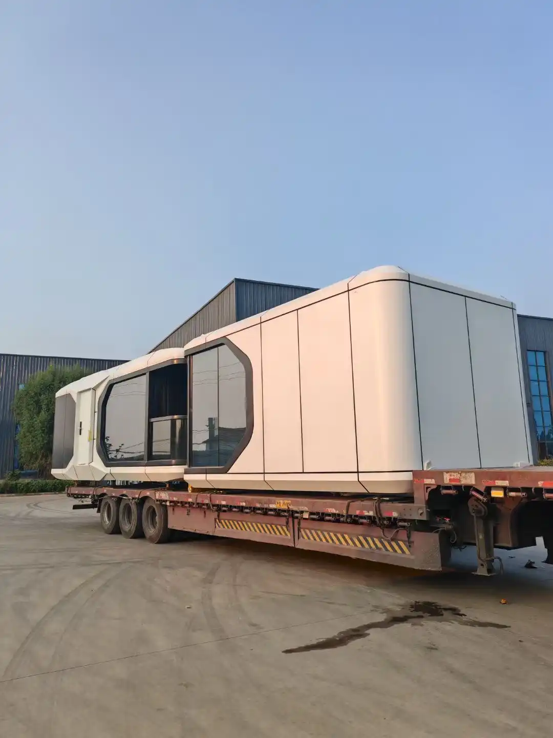 A premium space capsule house being precision-loaded for export, secured with heavy-duty straps and protective film to ensure safety during international sea freight.