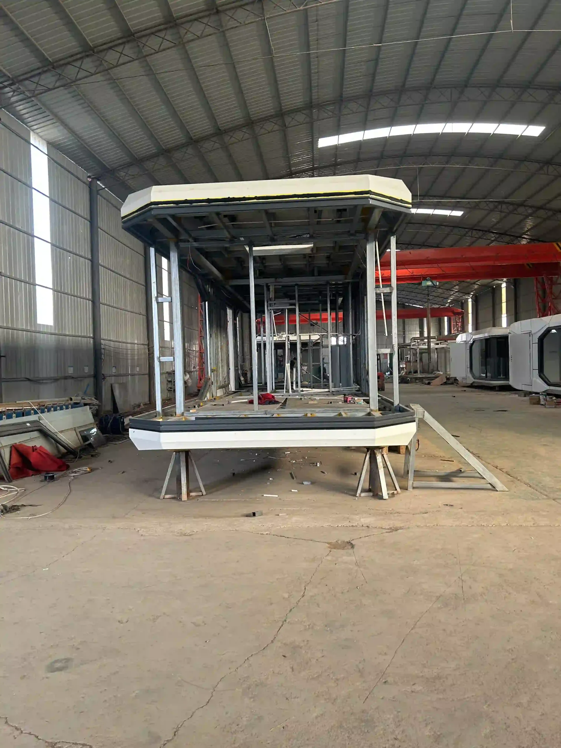 An interior view of a space cabin production line, showing the reinforced steel structure, aviation aluminum exterior cladding, and the high-density insulation layers used for extreme weather resistance.